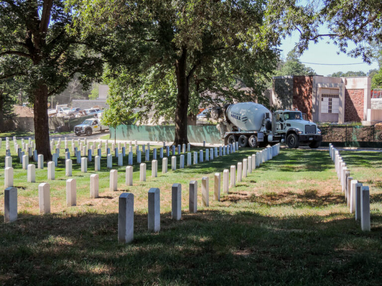 Rows of headstones at Arlington National Cemetery with a mixer truck working nearby
