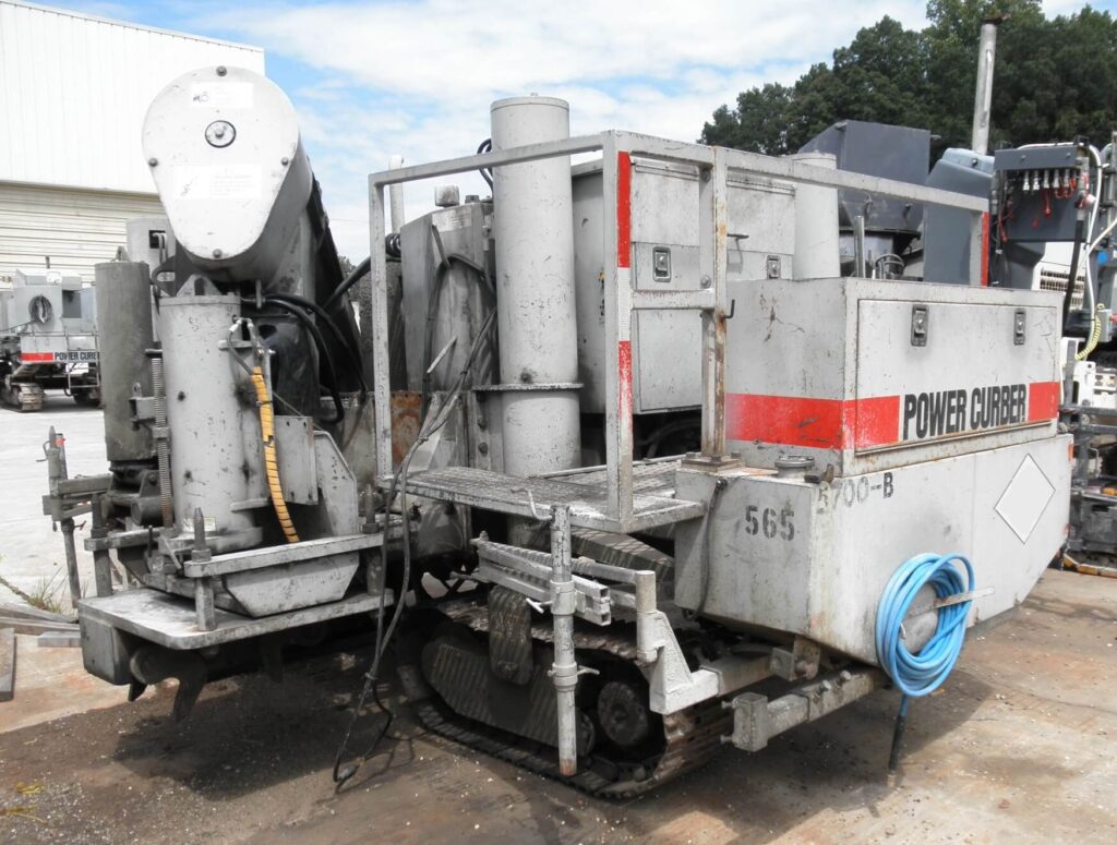 Power Curber 5700-B machine parked outside a warehouse