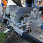 power curber machine creating curb and paving roads