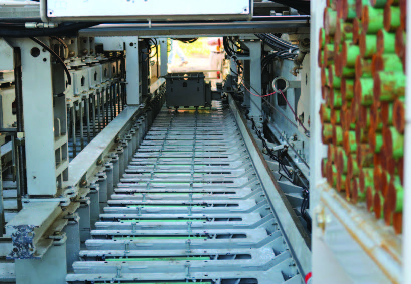 Close-up looking down a mold conveyor track with red and green rubber components