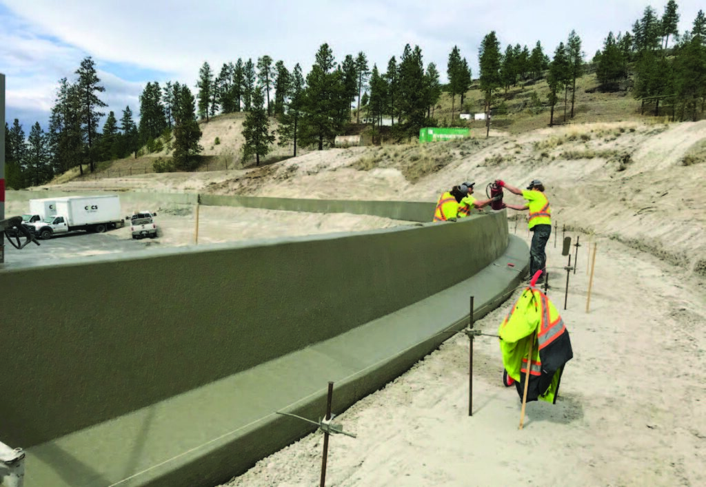 Construction team of 3 assembling race track barrier