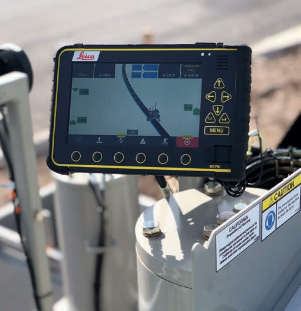 Handheld Leica MCP80 display showing stringless machine guidance software on a curbing machine.