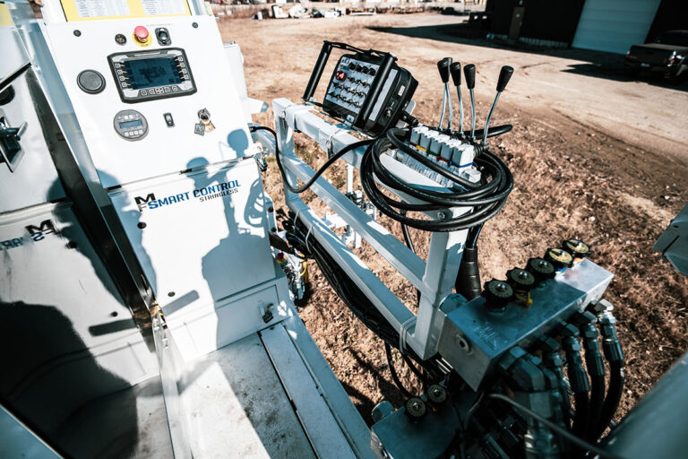 Close-up of the Miller Formless Smart Control stringless control panel with joysticks and gauges on an M-8100 machine.