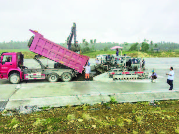 Airport using a dump truck for fast concrete supply to the paver at the Bicol International Airport