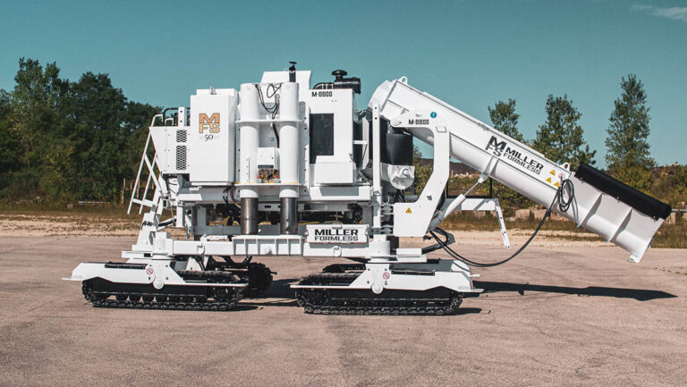 Miller Formless M-8800 machine parked on pavement with trees in the background, viewed from the side.