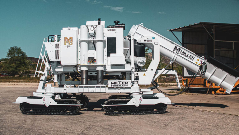 Miller Formless M-8800 machine with a 50th-anniversary badge parked near a metal building, showing its full conveyor arm.