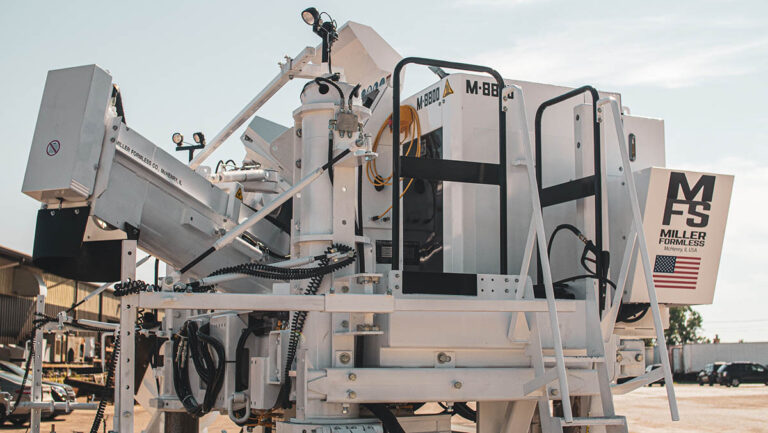 Miller Formless M-8800 machine parked outdoors near vehicles, showing its MFS badge and American flag decal.