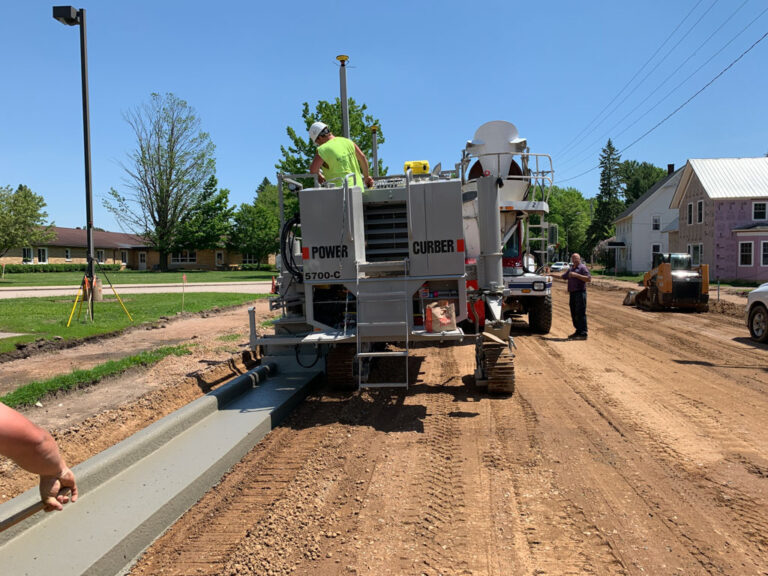 construction crew operating curb machine