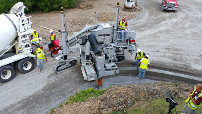 construction crew operating curb machine
