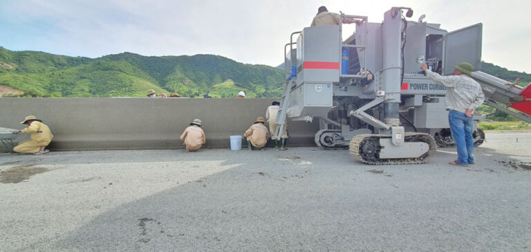 construction crew detailing a traffic barrier