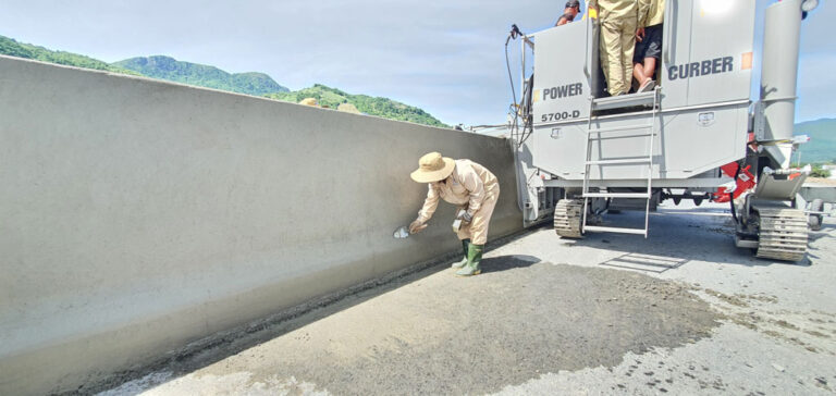 construction worker detailing newly set traffic barrier
