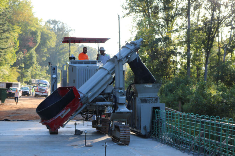 laying a bridge barrier over rebar frame