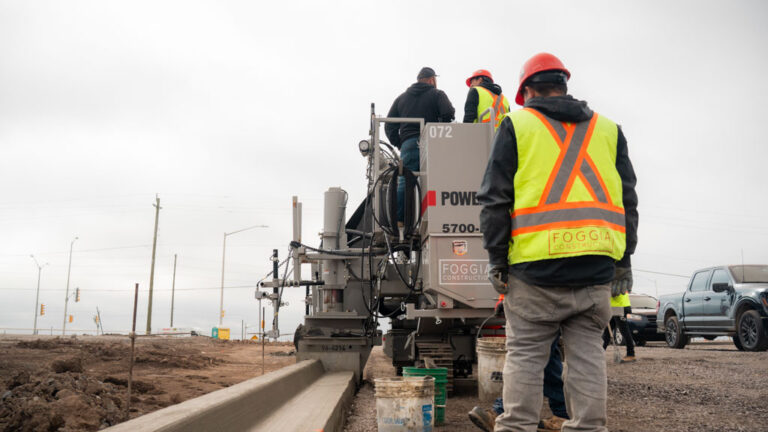 construction workers in reflective gear operating 5700-D machine