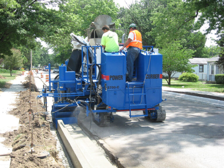 blue curb machine laying curb in residential neighborhood